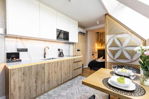 a kitchen and dining room with a table and a sink at Góralski Resort Family & SPA in Białka Tatrzanska