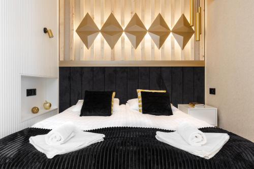 a bedroom with a large bed with towels on it at Góralski Resort Family & SPA in Białka Tatrzanska