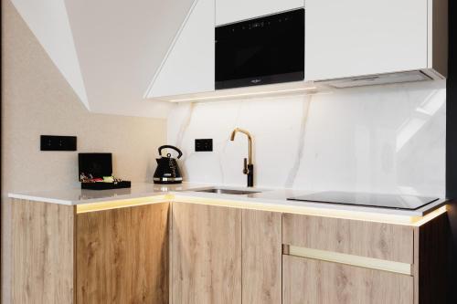 a kitchen with a sink and a microwave at Góralski Resort Family & SPA in Białka Tatrzanska