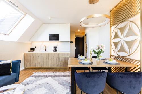 a kitchen and living room with a table and chairs at Góralski Resort Family & SPA in Białka Tatrzanska