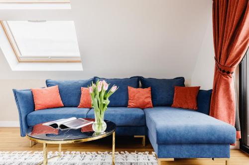 a blue couch with orange pillows and a table at Góralski Resort Family & SPA in Białka Tatrzanska
