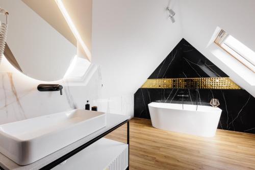 a bathroom with a white sink and a black wall at Góralski Resort Family & SPA in Białka Tatrzanska