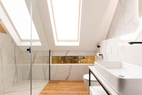 a bathroom with a sink toilet and a skylight at Góralski Resort Family & SPA in Białka Tatrzanska