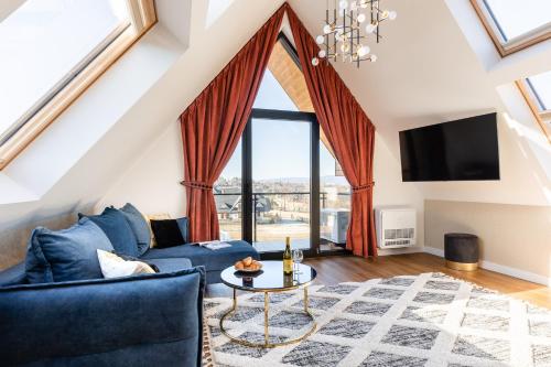a living room with a blue couch and a table at Góralski Resort Family & SPA in Białka Tatrzanska