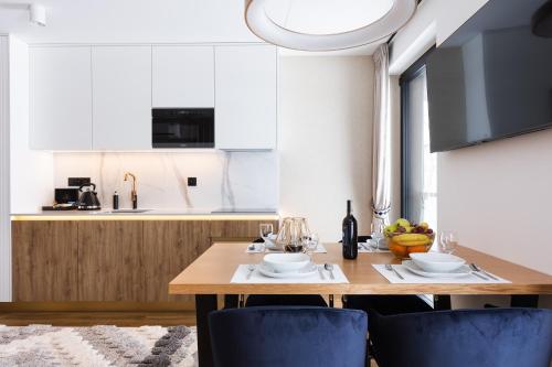 a kitchen with a wooden table and blue chairs at Góralski Resort Family & SPA in Białka Tatrzanska