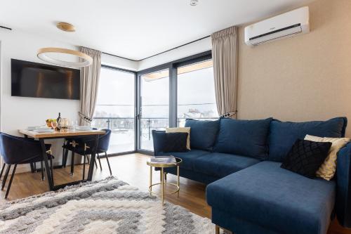 a living room with a blue couch and a table at Góralski Resort Family & SPA in Białka Tatrzanska