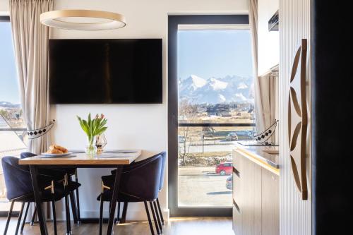 a dining room with a table and a large window at Góralski Resort Family & SPA in Białka Tatrzanska