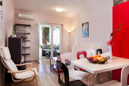 Un comedor y una sala de estar con mesa y sillas. en Holiday Home Porat, en Podgora
