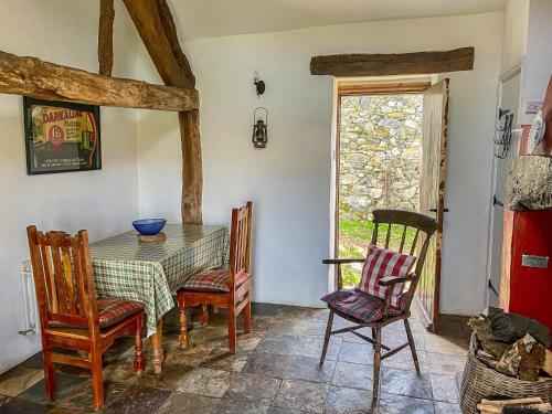 a dining room with a table and chairs and a window at Birkerthwaire Stable-w41477 in Eskdale