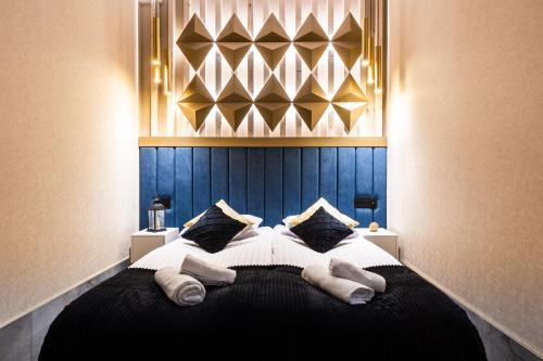 a bedroom with a bed with a blue head board at Góralski Resort Family & SPA in Białka Tatrzanska