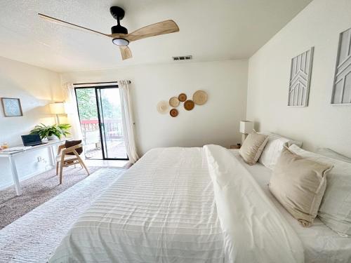 a white bedroom with a bed and a ceiling fan at Yosemite Adventure by Casa Oso in Oakhurst