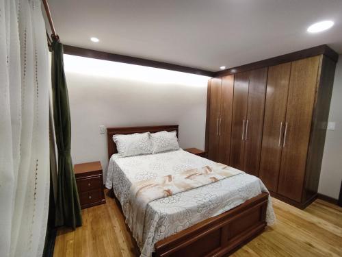 een slaapkamer met een bed en houten kasten bij GZ GUEST HOUSE in Cuenca