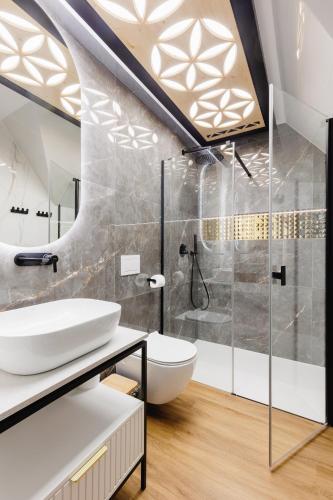 a bathroom with a sink and a shower and a toilet at Góralski Resort Family & SPA in Białka Tatrzanska