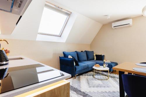 a living room with a blue couch and a window at Góralski Resort Family & SPA in Białka Tatrzanska