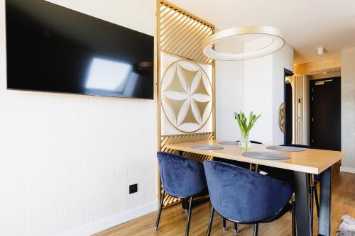 a dining room with a table and blue chairs at Góralski Resort Family & SPA in Białka Tatrzanska