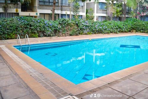 una piscina con tavolo al centro di Cosy House near Airport JKIA Train SGR a Nairobi