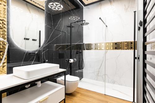 a bathroom with a shower and a toilet and a sink at Góralski Resort Family & SPA in Białka Tatrzanska