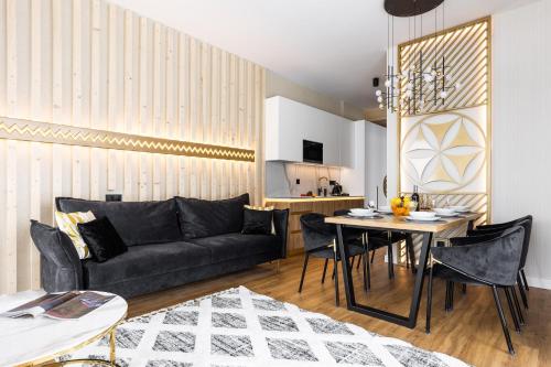 a living room with a couch and a table at Góralski Resort Family & SPA in Białka Tatrzanska