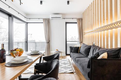 a living room with a gray couch and a table at Góralski Resort Family & SPA in Białka Tatrzanska