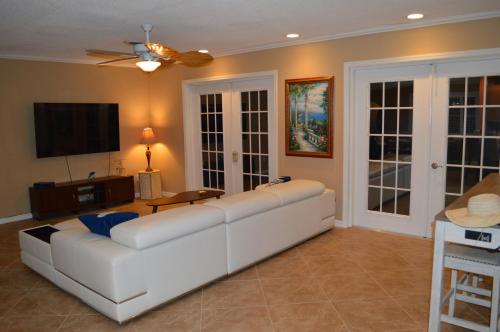 a living room with a white couch and a flat screen tv at Venice villa with heated pool, lanai, near beach in Venice