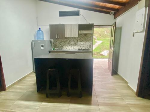 a kitchen with a counter and stools in a room at Eros Hostel & Brunch in Guatapé