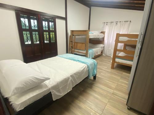 Eros Hostel & Brunch في غواتابيه: غرفة نوم فيها سرير وكرسي