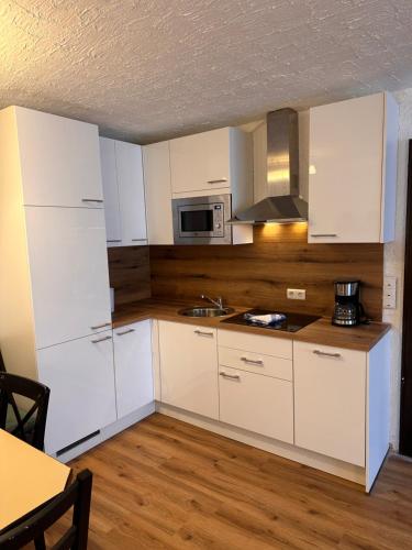 a kitchen with white cabinets and a sink at Weidach Zentrum 1 in Leutasch