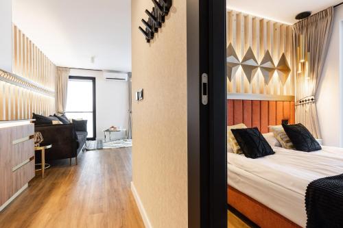 a bedroom with a bed and a living room at Góralski Resort Family & SPA in Białka Tatrzanska