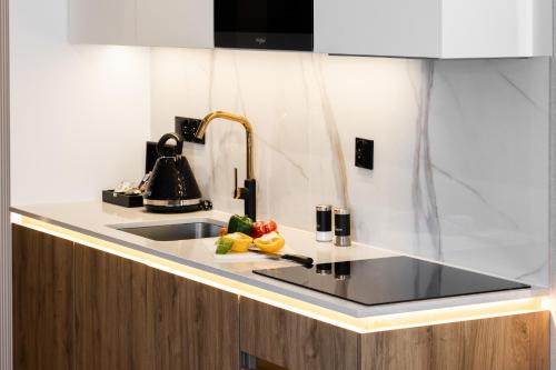a kitchen counter with a sink and vegetables on a cutting board at Góralski Resort Family & SPA in Białka Tatrzanska