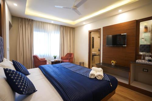 a hotel room with a bed and a television at Shalom Backpackers Mussoorie in Mussoorie