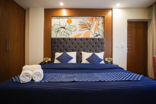 a bedroom with a blue bed with towels on it at Shalom Backpackers Mussoorie in Mussoorie