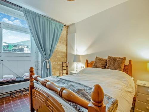 a bedroom with a large bed and a window at Fletchers Knapp in Bisley