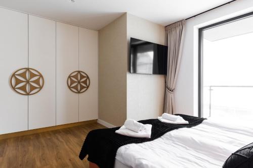 a bedroom with a bed with white towels on it at Góralski Resort Family & SPA in Białka Tatrzanska