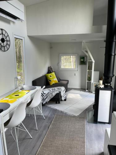 a living room with a couch and a table and chairs at Luxus Tiny House Saagala in Tornio