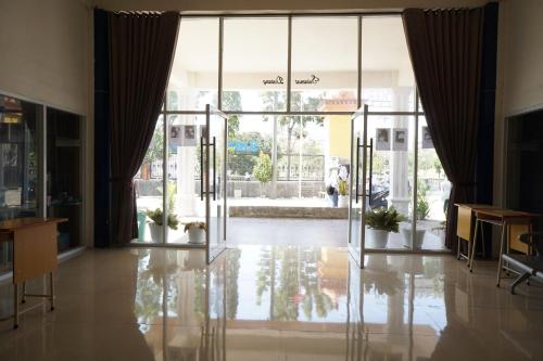 eine offene Lobby mit Glastüren und Topfpflanzen in der Unterkunft OYO 93205 Kusuma Hotel And Convention Hall in Nganjuk