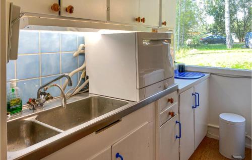 a kitchen with a sink and a microwave at 2 Bedroom Lovely Home In Nykvarn in Nykvarn