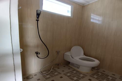 ein kleines Bad mit einem WC und einer Dusche in der Unterkunft OYO 93207 Merah House in Pekanbaru