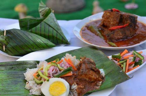 a table with plates of food and a bowl of soup at Seri Ibai Permai in Kuala Terengganu