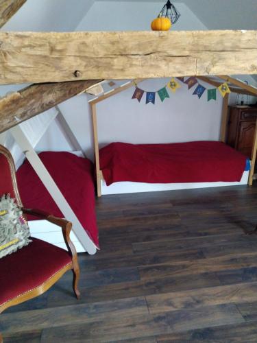 a room with a bed and a chair in a attic at Le Petit Gite des sorciers in Chitray