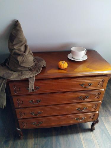 a dresser with a hat and a cup on it at Le Petit Gite des sorciers in Chitray