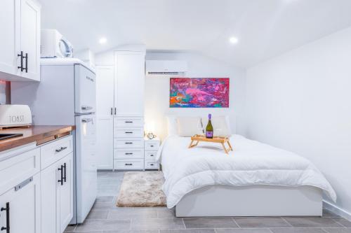 a white kitchen with a bed and a table at Smart Tiny House Garden in Miami Gardens