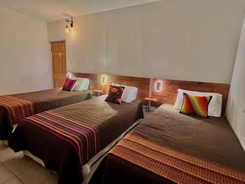 Habitación de hotel con 2 camas y almohadas coloridas en Baja Real Hotel Boutique en La Paz