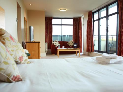a hotel room with a large bed and a living room at Green Isle Hotel, Dublin in Clondalkin 