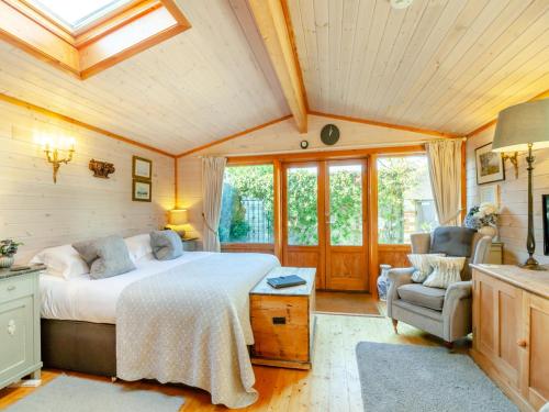 1 dormitorio con 1 cama y 1 silla en una habitación en The Lodge, en Hurstpierpoint