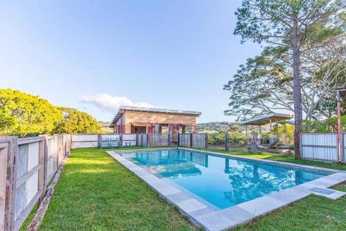 a swimming pool in the yard of a house at Byron Sunset Cottage in Ewingsdale