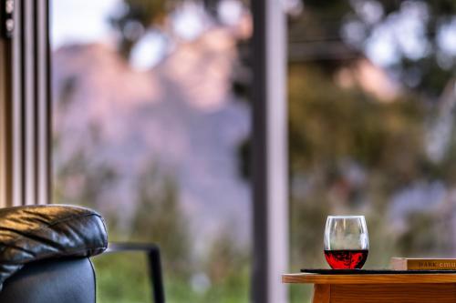 a glass of red wine sitting on a table at Driftwood in Coles Bay