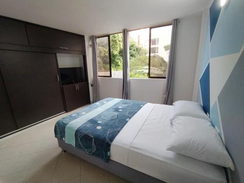 1 dormitorio con cama y ventana grande en Apartalofts Cali - Hermoso Loft Zona Oeste 25 m2, en Cali