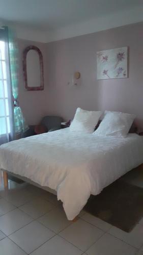 a bed with white sheets and pillows in a bedroom at O'jardin in Arthez-de-Béarn