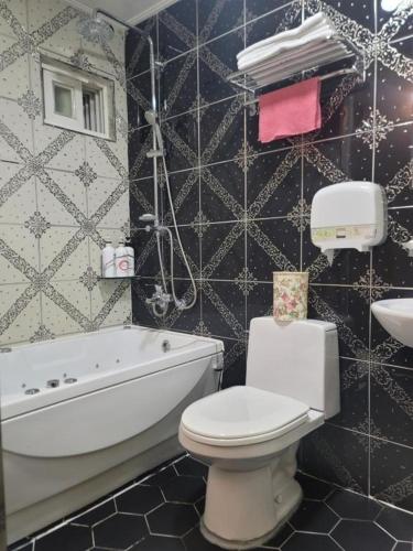 łazienka z wanną, toaletą i umywalką w obiekcie Cozy w Seulu