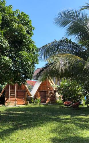 a house with a palm tree in front of it at Lazy Bones in Koh Rong Sanloem